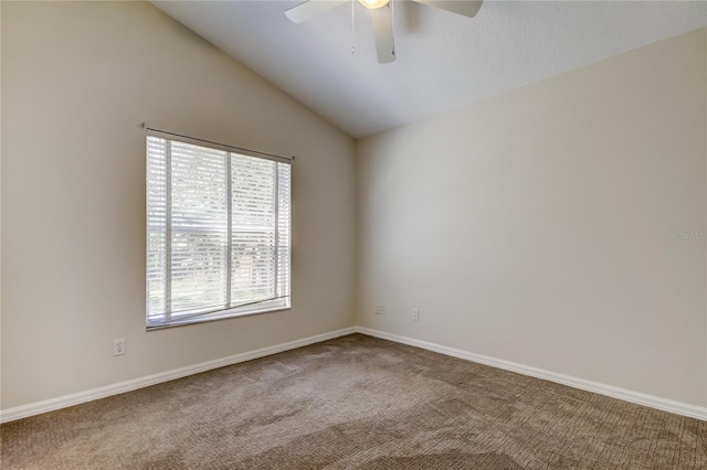 carpeted spare room featuring vaulted ceiling and ceiling fan