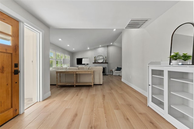 kitchen featuring light hardwood / wood-style flooring, a large fireplace, and lofted ceiling