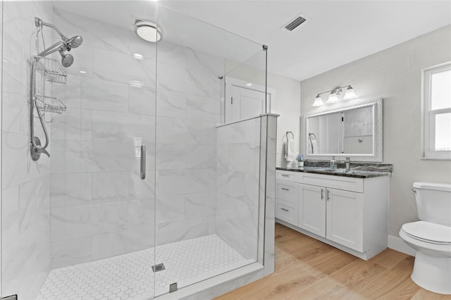 bathroom with a shower with door, toilet, hardwood / wood-style flooring, and vanity