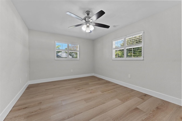 spare room with a healthy amount of sunlight, ceiling fan, and light hardwood / wood-style floors