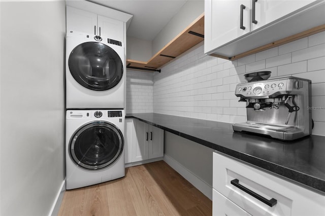 laundry room featuring light hardwood / wood-style flooring and stacked washer / drying machine