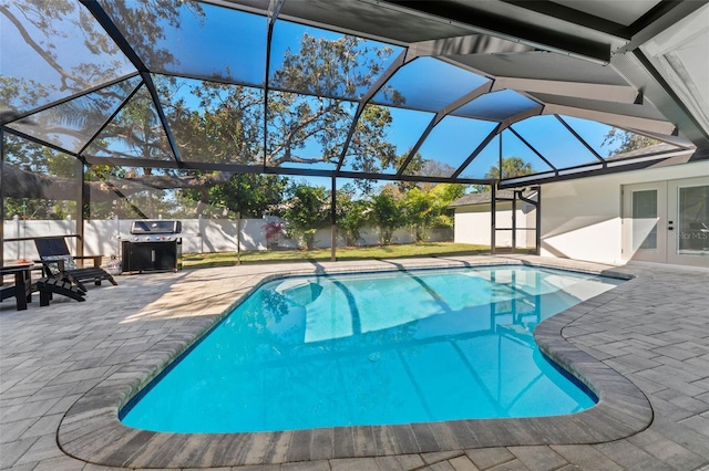 view of pool featuring a patio area, area for grilling, and glass enclosure