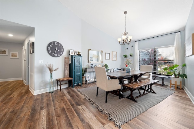 dining room with a notable chandelier, high vaulted ceiling, and dark hardwood / wood-style floors