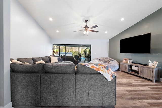 living room with hardwood / wood-style flooring, ceiling fan, and lofted ceiling