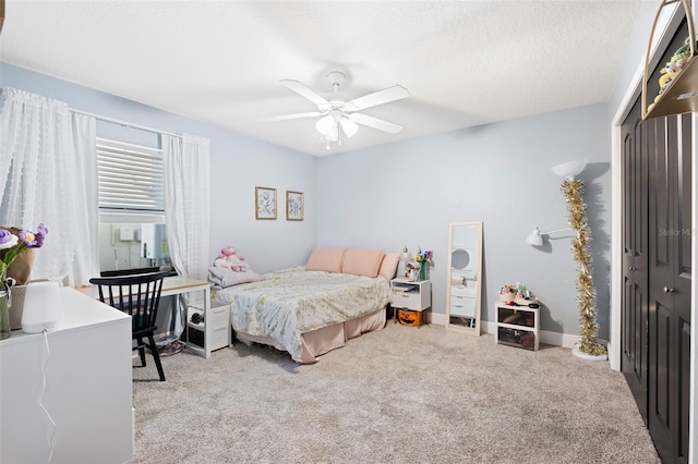 carpeted bedroom featuring ceiling fan, a textured ceiling, and a closet