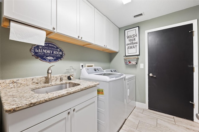 laundry area featuring sink, cabinets, and washer and dryer