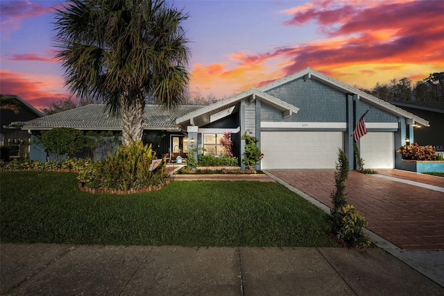 view of front of property with a yard and a garage