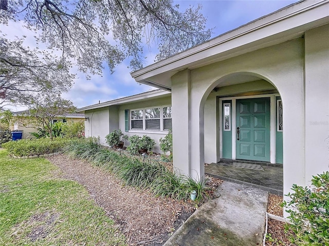 doorway to property featuring stucco siding