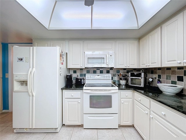 kitchen with light tile patterned flooring, white cabinets, backsplash, and white appliances