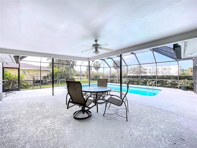 outdoor pool featuring ceiling fan, glass enclosure, and a patio