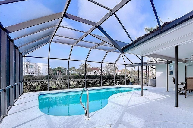 outdoor pool with a lanai, ceiling fan, and a patio area