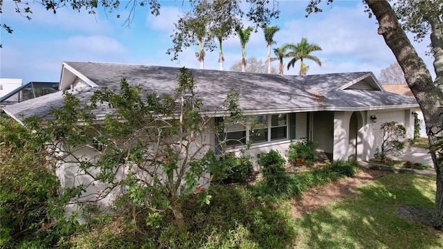 view of front of house featuring stucco siding, an attached garage, and roof with shingles