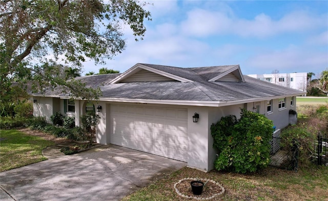 ranch-style house featuring concrete driveway, stucco siding, a shingled roof, and a garage