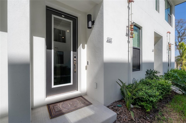 doorway to property featuring stucco siding