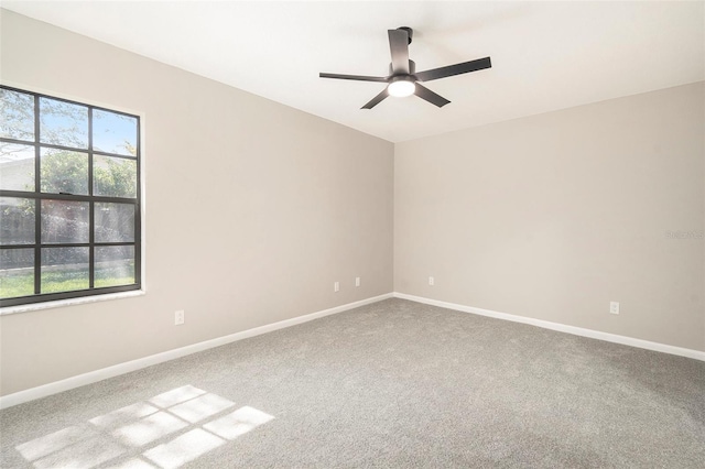 carpeted spare room featuring ceiling fan