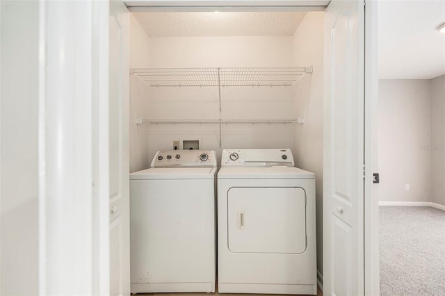 laundry room with washer and clothes dryer, carpet flooring, and a textured ceiling