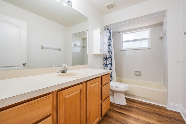 full bathroom featuring toilet, wood finished floors, vanity, visible vents, and shower / bath combination with curtain