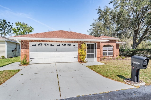 single story home with an attached garage, driveway, brick siding, and a front yard