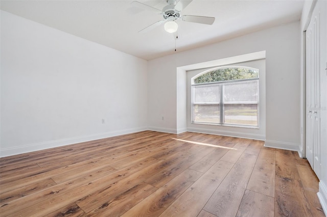 unfurnished room featuring ceiling fan, light wood-type flooring, and baseboards