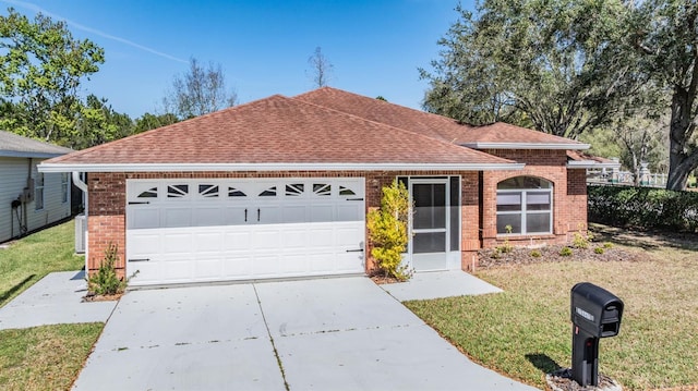 ranch-style home featuring driveway, brick siding, a shingled roof, an attached garage, and a front yard