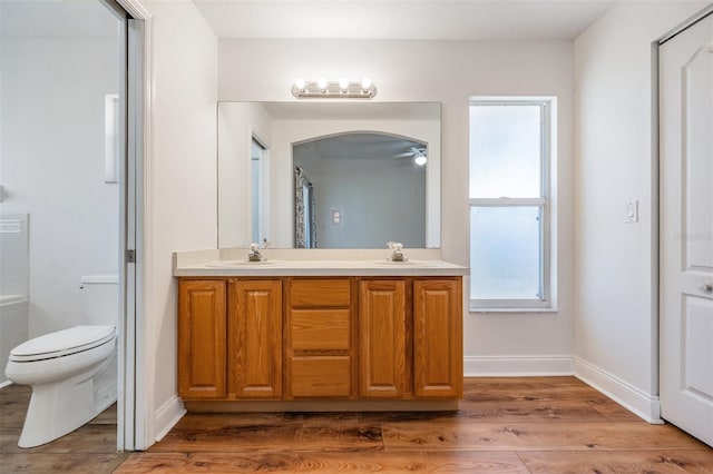 full bath featuring double vanity, wood finished floors, and a sink