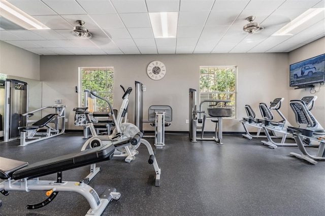 workout area with a healthy amount of sunlight, baseboards, and a drop ceiling