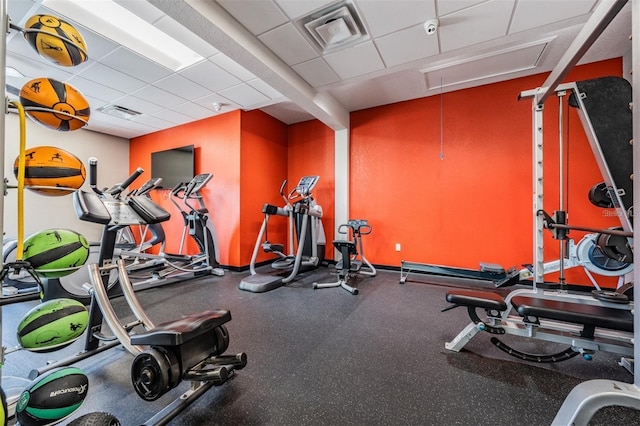 gym featuring attic access, a drop ceiling, and visible vents