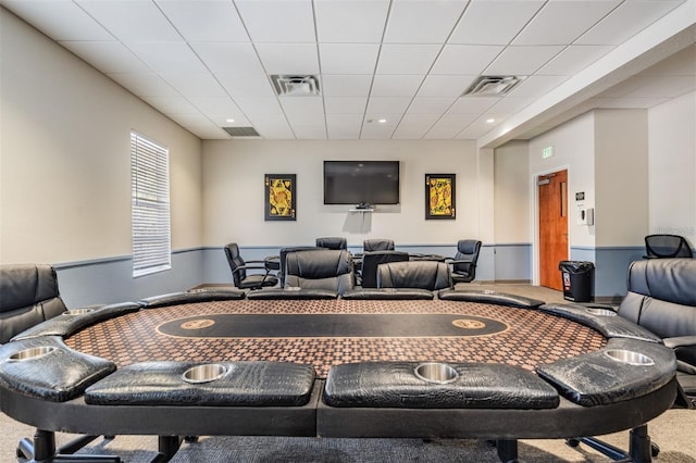 carpeted cinema room featuring visible vents and a paneled ceiling