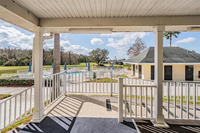 view of patio / terrace with a community pool and fence