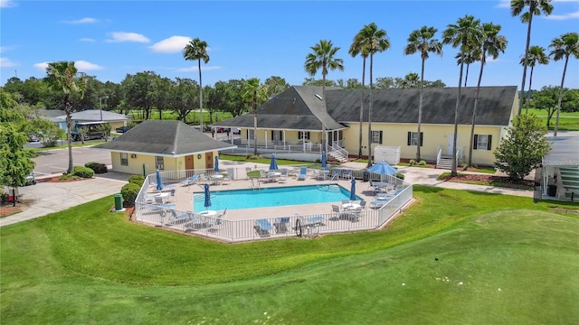 community pool featuring fence, a lawn, and a patio