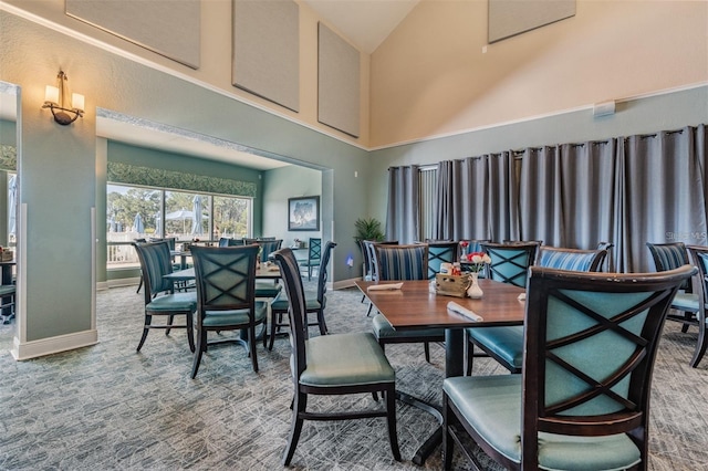 dining area featuring baseboards, high vaulted ceiling, and carpet flooring