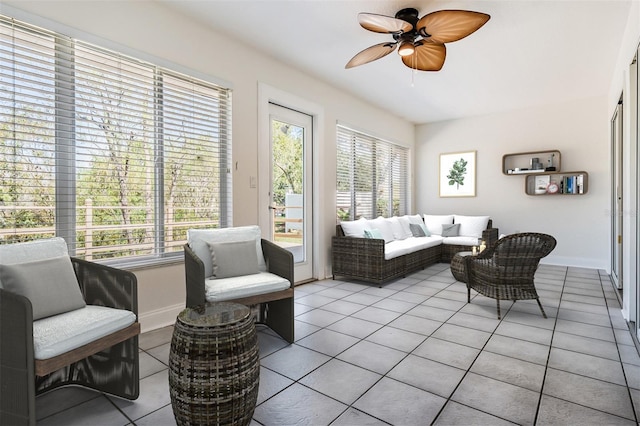 living area featuring ceiling fan, light tile patterned floors, and a healthy amount of sunlight