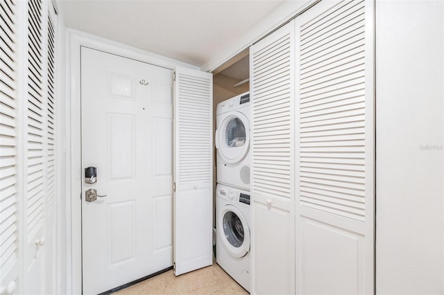 washroom featuring stacked washer and clothes dryer and light tile patterned floors