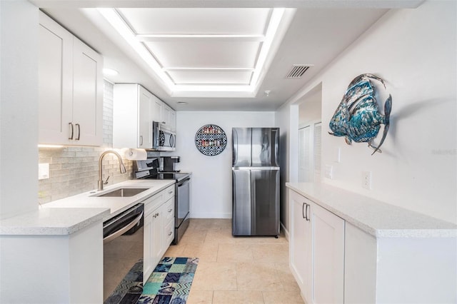 kitchen featuring sink, stainless steel appliances, light stone countertops, decorative backsplash, and white cabinets