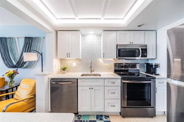 kitchen with sink, white cabinets, decorative backsplash, light tile patterned floors, and stainless steel appliances