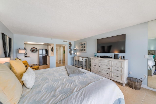 bedroom with a textured ceiling and light tile patterned floors