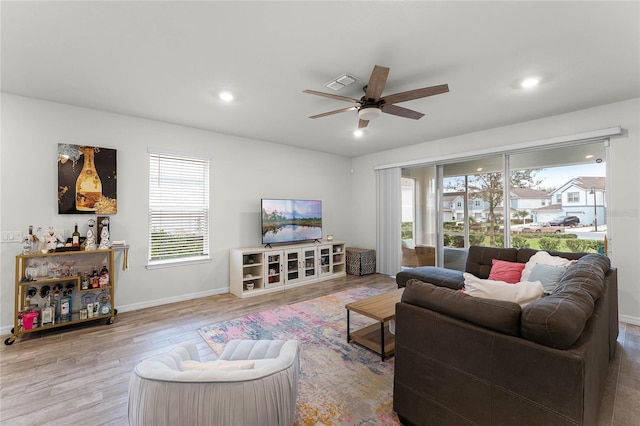 living area featuring light wood finished floors, recessed lighting, visible vents, a ceiling fan, and baseboards