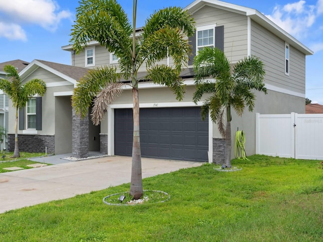 view of front facade with stucco siding, concrete driveway, fence, stone siding, and a front lawn