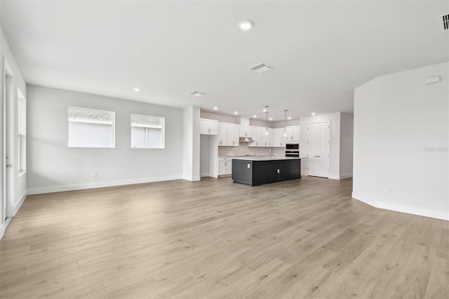 11885 Richmond Trl, Parrish, FL 34219 - unfurnished living room featuring recessed lighting, baseboards, light wood finished floors, and a sink