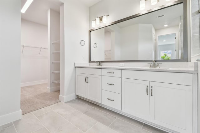 11885 Richmond Trl, Parrish, FL 34219 - bathroom featuring double vanity, a walk in closet, baseboards, and tile patterned flooring