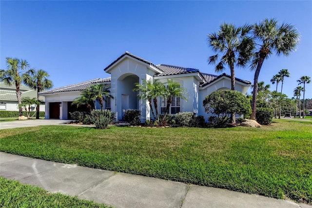 mediterranean / spanish home with a front yard and a garage