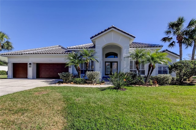 mediterranean / spanish home featuring a garage, french doors, and a front yard