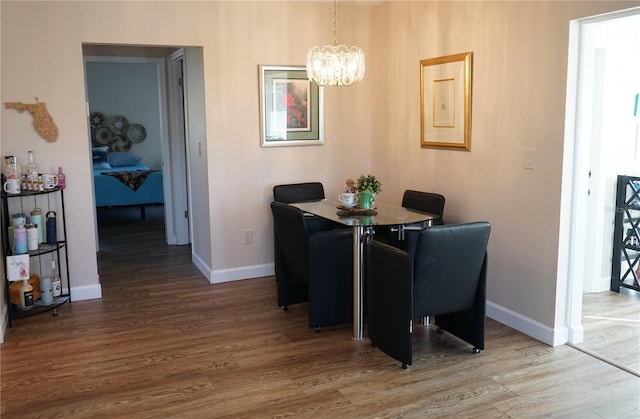 dining space with hardwood / wood-style floors and a chandelier