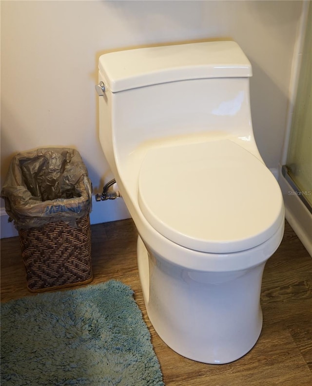 details with hardwood / wood-style flooring and toilet