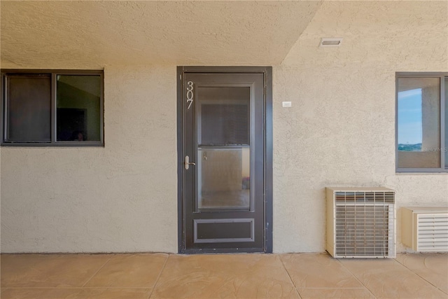 property entrance with a patio and stucco siding