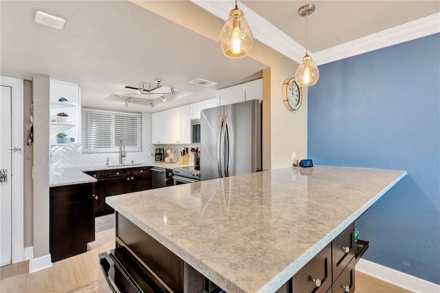 kitchen featuring decorative light fixtures, visible vents, appliances with stainless steel finishes, white cabinets, and a sink