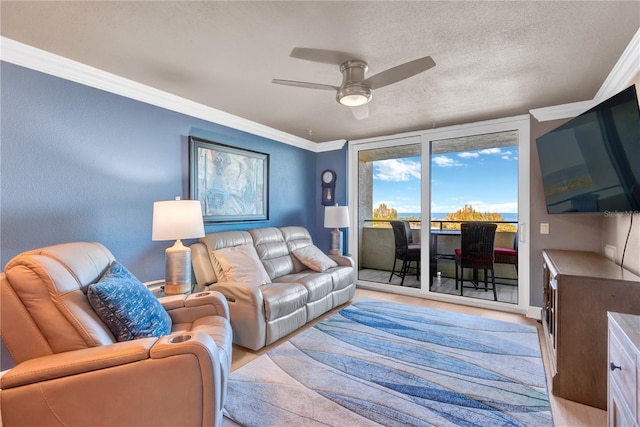 living room featuring a textured ceiling, a ceiling fan, and crown molding