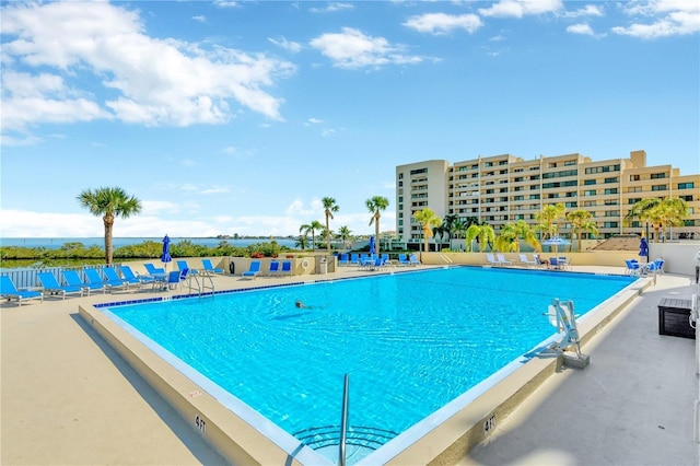 community pool with a water view and a patio