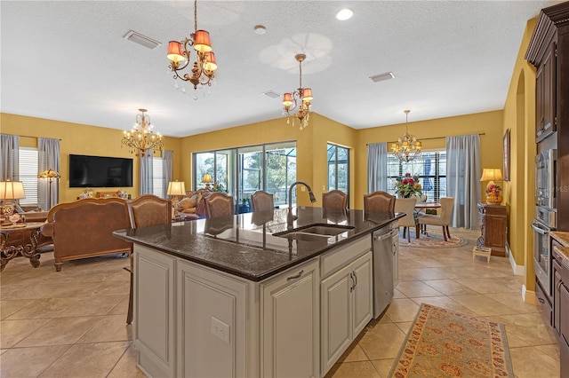 kitchen featuring visible vents, a chandelier, stainless steel appliances, and a sink