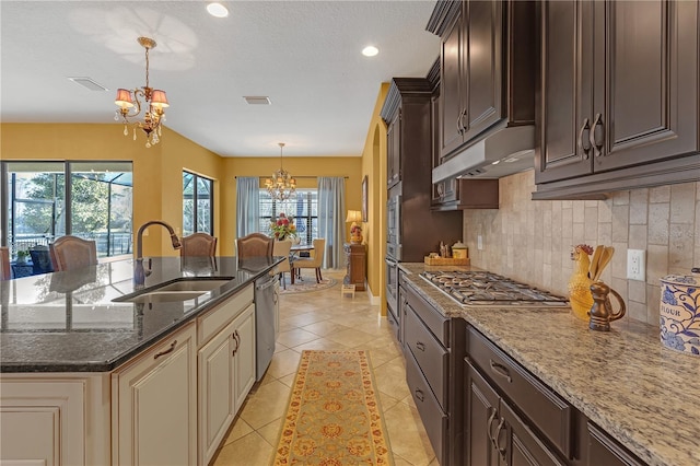 kitchen featuring stainless steel appliances, light tile patterned flooring, a sink, a chandelier, and under cabinet range hood